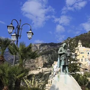 View from waterfront to statue, town of Amalfi and hillside, Costiera Amalfitana (Amalfi Coast)