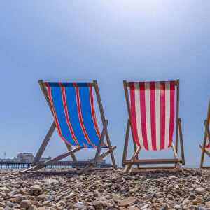 View of Worthing Pier and colourful deckchairs on Worthing Beach, Worthing, West Sussex