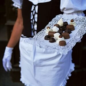 Waitress carrying tray of chocolate