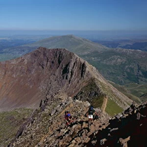 Walkers approaching the summit of Mount Snowdon from the ridge of Y Lliwedd