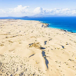 White sand dunes meeting the blue Atlantic Ocean, aerial view, Corralejo Nature Park