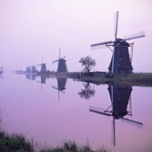 Windmills in early morning mist