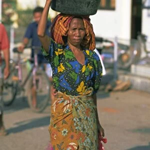 Woman carrying basket of fruit on her head