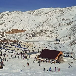 Woman on chairlift above crowds of skiers and tourists at the Neve Ativ Ski Resort on Mount Hermon
