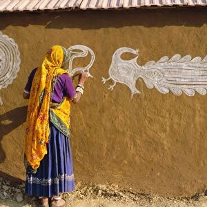 Woman decorating her house with traditional local designs