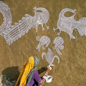 Woman painting designs on her house