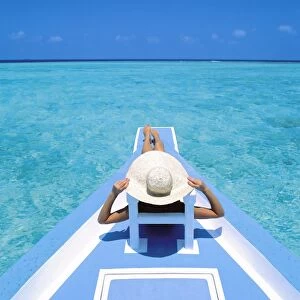 Woman relaxing on deck of boat, Maldives, Indian Ocean, Asia