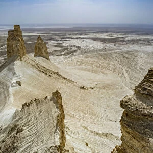 Woman sitting on a giant rock cliff, Bozzhira Canyon, Ustyurt plateau, Mangystau, Kazakhstan, Central Asia, Asia
