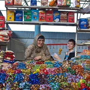 Woman and her son selling sweets on a market stand in the Bazaar of Osh