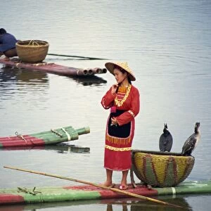 Woman in traditional dress on a raft with cormorants on the Lijiang (River Li) in Guanxi Province