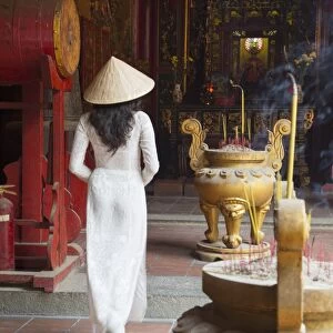 Woman wearing ao dai dress at Ha Chuong Hoi Quan Pagoda, Cholon, Ho Chi Minh City