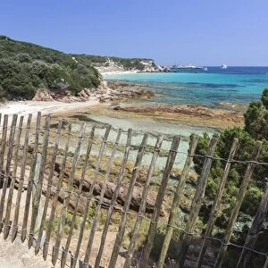 The wooden fence frames the limestone rocks and turquoise sea, Sperone, Bonifacio