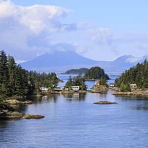 Wooden houses on small forested islands, clearing morning mists, Sitka Sound, Sitka