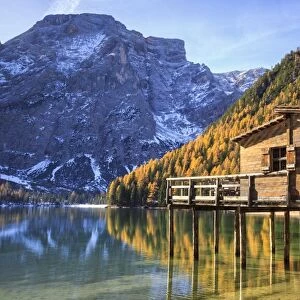 Wooden hut and colourful woods reflected in Lake Braies, Natural Park of Fanes Sennes