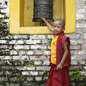 Young monk and prayer wheel, Swayambhunath temple, Kathmandu, Nepal, Asia