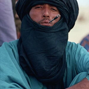 Young Tuareg man smoking small pipe and wearing headscarf, Timbuktu, Mali, West Africa, Africa