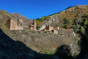 Quiet Prints: Abandoned mountain village situated in Caucasus region of Russia with old stone buildings under clear blue sky