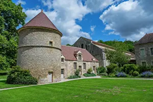 Walls Prints: Abbey of Fontenay features round tower and stone buildings in green landscape with clouds above in France