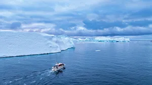 Boat Ride Prints: Aerial of a boat between the icebergs of the Ilulissat Icefjord