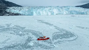 Outdoor Activity Prints: Aerial of a little ship floating between the ice below the Eqi glacier