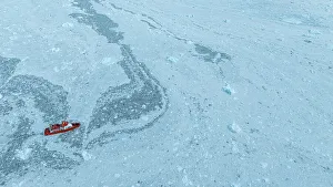 Eco Tourism Prints: Aerial of a little ship floating between the ice below the Eqi glacier