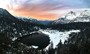 Valtellina Prints: Aerial panoramic view of snowy forest and frozen lake Entova at sunrise
