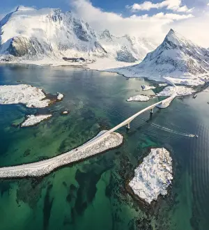Transport Infrastructure Prints: Aerial panoramic view of snowy peak of Volanstinden and Fredvang bridge, Lofoten Islands