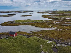 Grasslands Prints: Aerial of a red boat shed on the rugged coastline of the UNESCO World Heritage Site