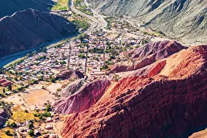 Settlement Prints: Aerial view of the ancient village of Purmamarca in a valley framed by red rocks mountains