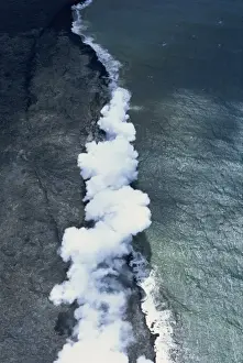 Big Island Prints: Aerial view of basalt lava field with collapsed roof window into an active flowing lava tube on the south flank of