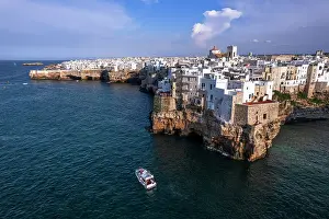Fishing Village Prints: Aerial view of a boat sailing off the coast of Polignano a Mare fishing village