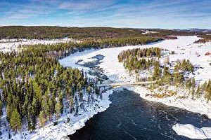 Aerial view of bridge above the scenic Jockfall waterfall in winter, Overkalix, Norrbotten county, Lapland Sweden