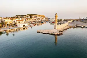 Rethymno Prints: Aerial view of the calm sea at dawn surrounding the old Venetian port and lighthouse