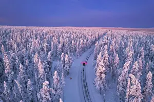 Akaslompolo Prints: Aerial view of a car driving through the winter forest covered from snow at dawn