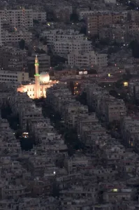 Damascus Prints: Aerial view of city at night including a floodlit mosque