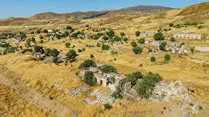 Settlement Prints: Aerial view of the damaged village of Jabrayil showing ruins and vegetation in a dry landscape in Azerbaijan