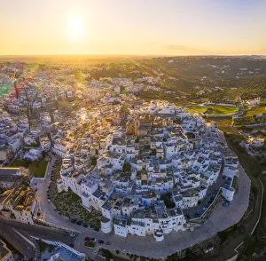 Aerial view by drone of the old town of Ostuni at sunset, Apulia, Italy, Europe