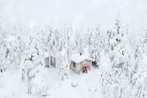 2 People Prints: Aerial view of happy couple enjoying the winter holidays in a frozen hut in the snowy forest
