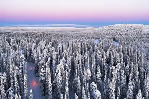 2 People Prints: Aerial view of two hikers walking in the snowcapped forest at dawn