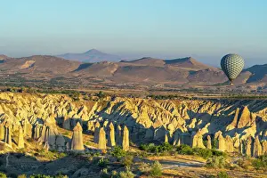 Famous Landmarks Prints: Aerial view of hot air balloon over rock formations in Love Valley at sunrise