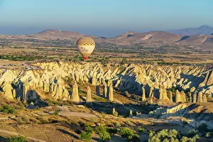 Cappadocia Prints: Aerial view of hot air balloon over rock formations in Love Valley at sunrise