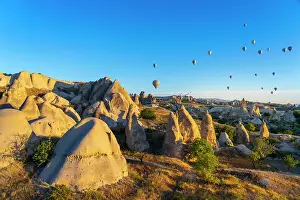 Historical Site Prints: Aerial view of hot air balloons over rock formations at sunrise
