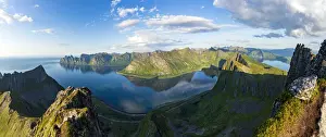Aerial view of Husfjellet mountain and Devils Teeth peaks reflected in the fjord