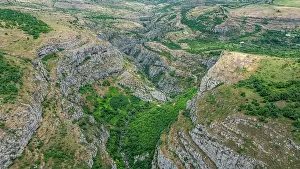 Canyon Prints: Aerial view of a large canyon with steep cliffs and green vegetation in Qarabaqh region