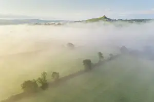 Aerial view over mist shrouded countryside towards Brentor Church, Dartmoor National Park, Devon, England, United Kingdom, Europe