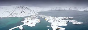 Aerial view of mountains and sea surrounding Sorvaer after a snow blizzard, Soroya Island