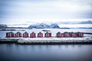 Nordland Gallery: Aerial view of red rorbu cabins in a row amidst the cold sea in winter, Svolvaer, Nordland county