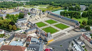Lawn Prints: Aerial view showing the architecture and gardens of Fontainebleau palace in France with surrounding landscape