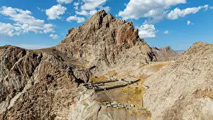 Range Prints: Aerial view shows Alinja castle surrounded by hills and mountains in Azerbaijan under a blue sky