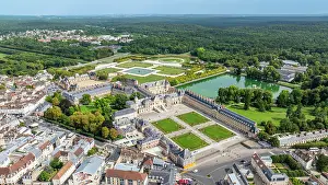 Ponds Prints: Aerial view shows Fontainebleau palace and surrounding gardens in France with greenery in the distance during daytime